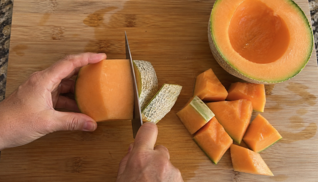 ChatGPT Image Jun 10, 2026, 05_33_31 PM Hands removing cantaloupe rind on cutting board with seeds scraped out