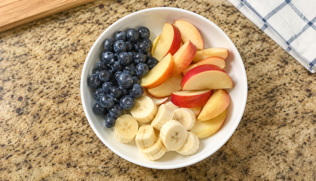 ChatGPT Image Jun 20, 2026, 11_50_03 PM Bowl of fresh blueberries, apple slices, and banana as dog treat alternatives
